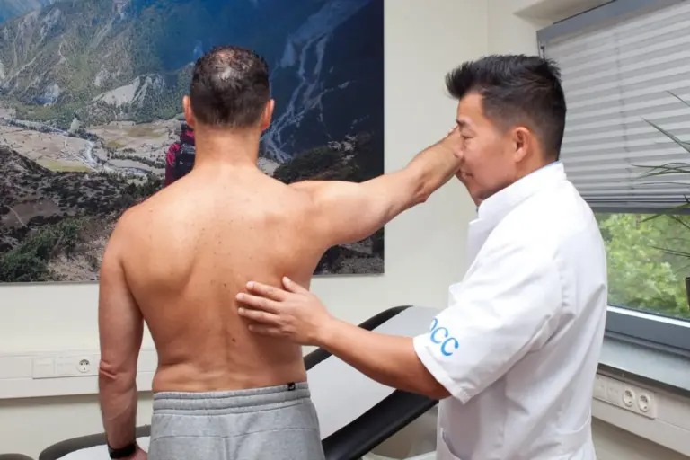 Dr. John Cheung assessing a patient’s shoulder mobility at Orthopedic Care Clinics in Amsterdam.
