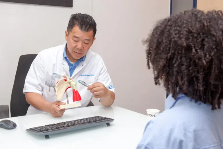 Orthopedic surgeon explaining shoulder anatomy to a patient during a consultation in Amsterdam.